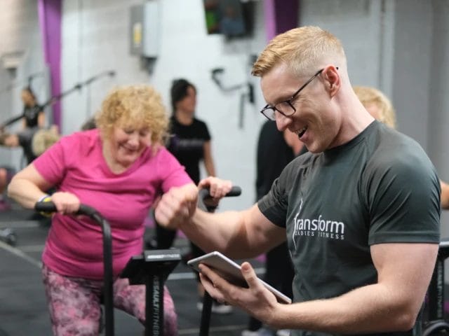 Group of women riding exercise bike in gym